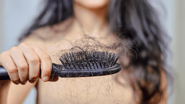 Woman holding brush with hair