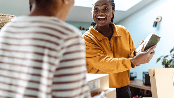 Woman excitedly showing friend a package