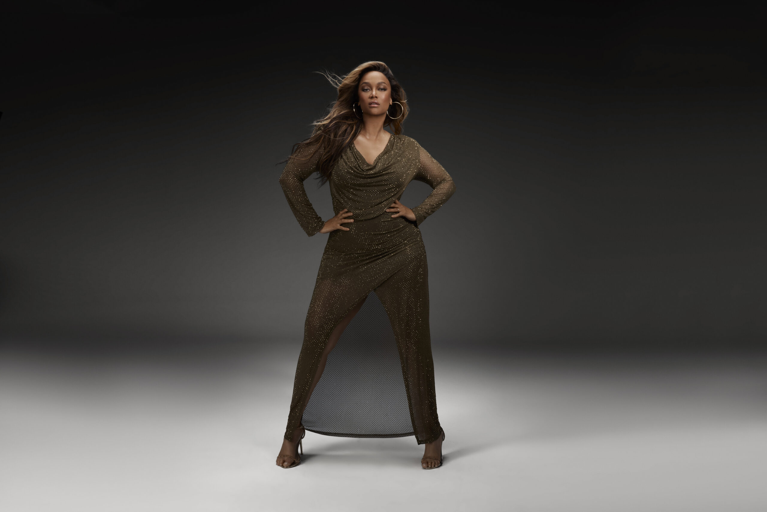 Tyra Banks wearing the Jersey Hotfix Maxi dress for promotional photo in collaboration with Karen Miller